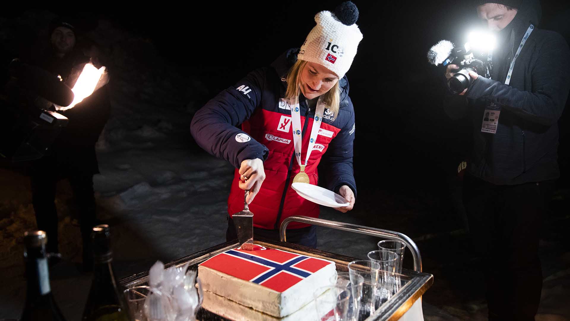 Skiskytter Marte Olsbu Røiseland feirer med kake etter å ha sikret VM-gull i 2020. Hun er en av flere toppidrettsutøvere som nå åpner opp om sitt forhold til mat. Foto: Berit Roald / NTB